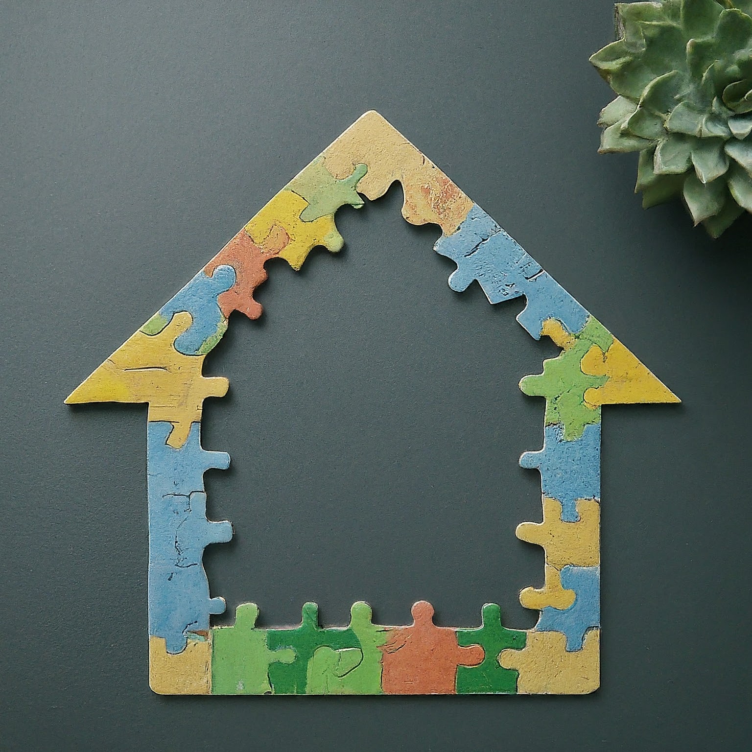 A colorful jigsaw puzzle depicting a house, on a black background.